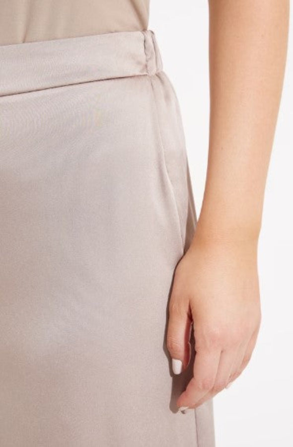 Close-up of a person wearing beige pants with a white background