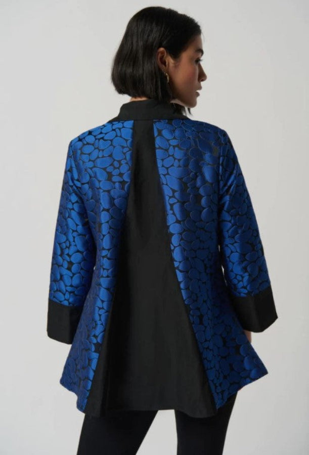 Blue patterned jacket worn by a person on a white background