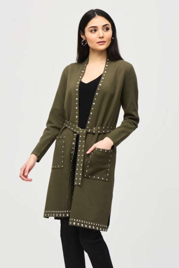 Woman wearing an olive green cardigan with studded details on a white background