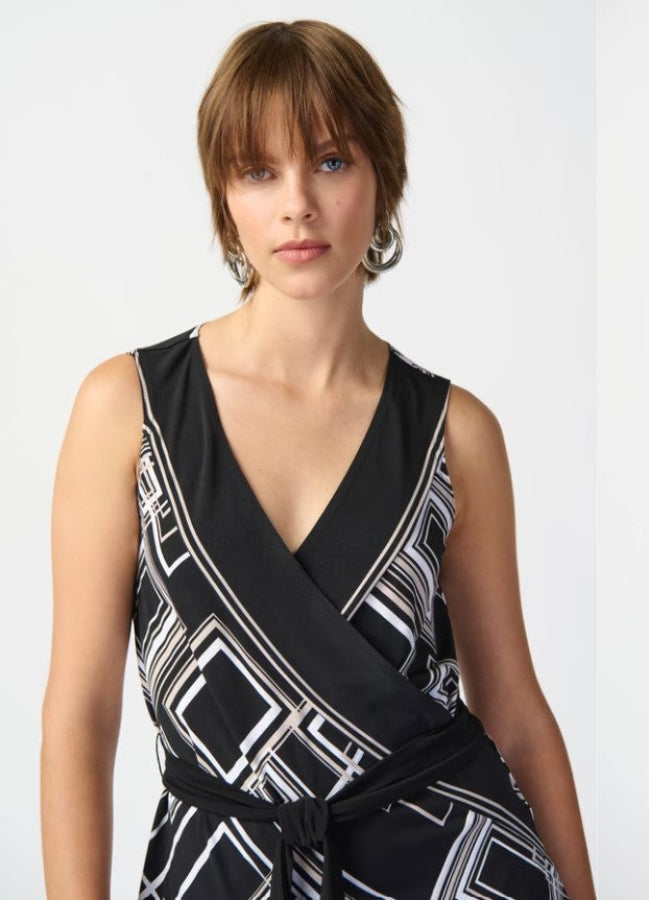 Woman wearing a black and white patterned top against a plain background
