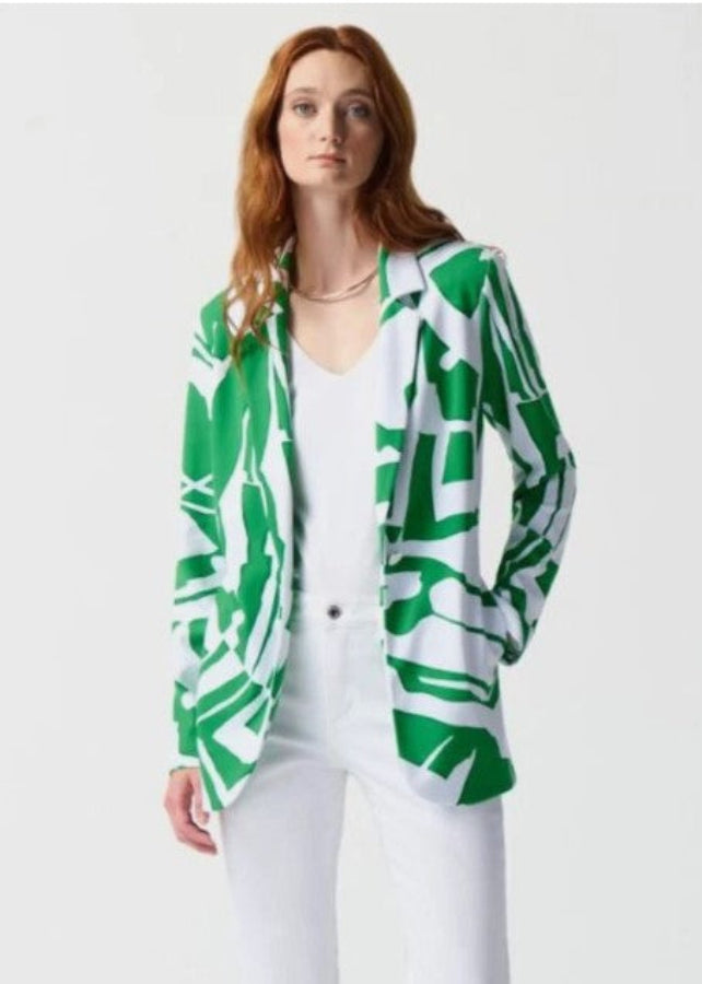 Woman wearing a green and white patterned blazer on a plain background