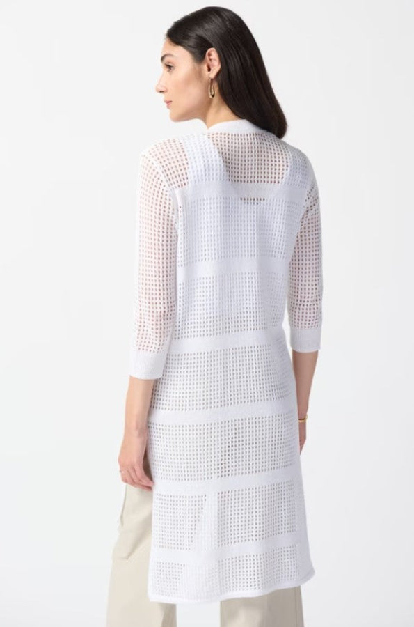 Woman wearing a white knit cover-up on a plain background