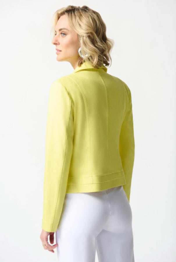 Woman wearing a yellow jacket and white pants on a white background