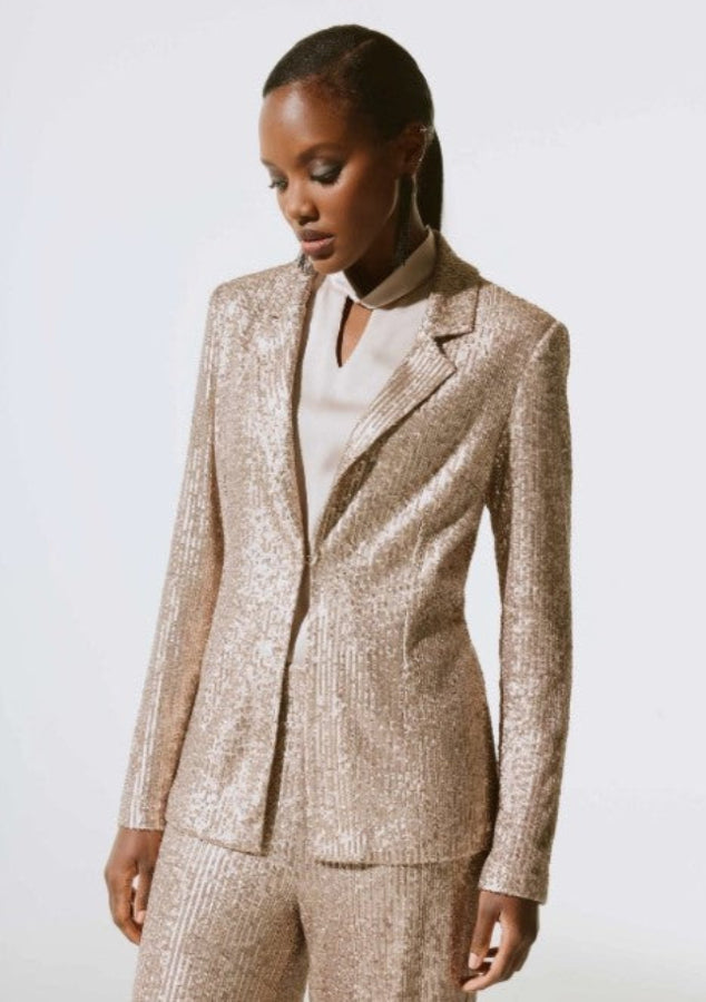 Woman wearing a beige suit against a white background