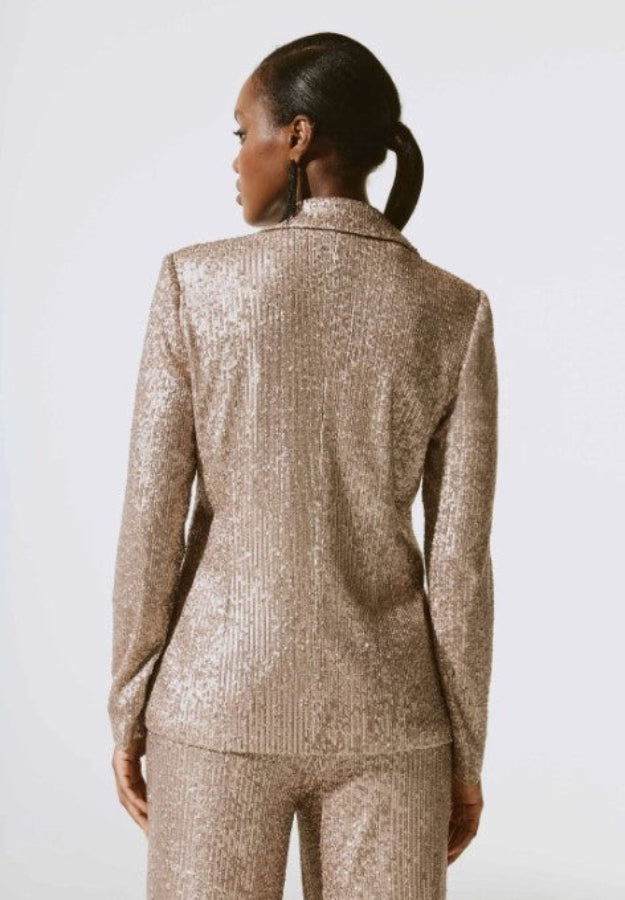 Person wearing a sparkly gold suit on a white background