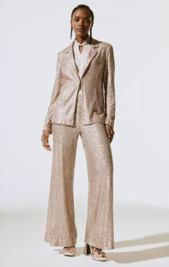 Person wearing a beige sequin suit on a white background