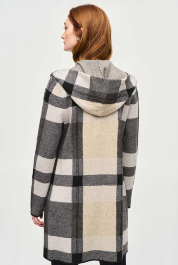 Person wearing a checkered coat with a hood on a white background