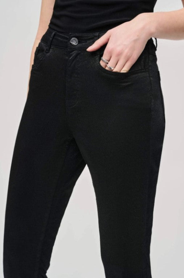 Person wearing black jeans on a plain background