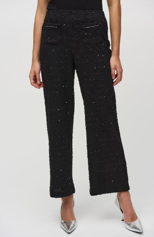 Black textured pants worn by a person on a white background