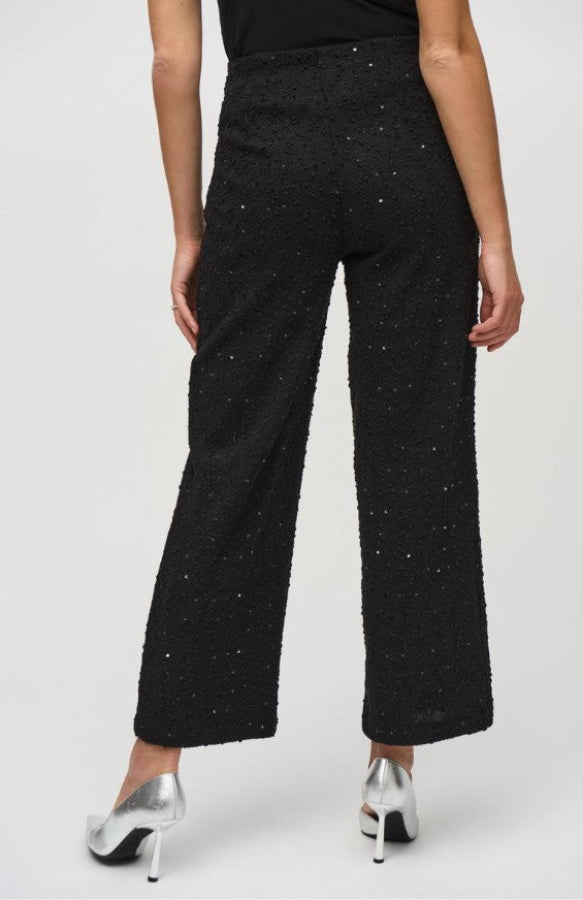 Black textured pants worn by a person on a white background