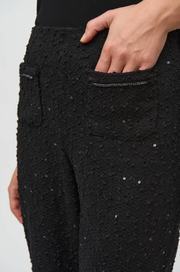 Black textured pants with sequin details on a white background