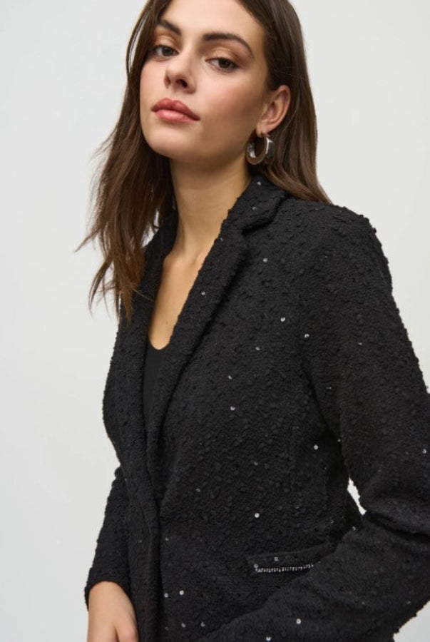 Woman wearing a black textured blazer against a white background