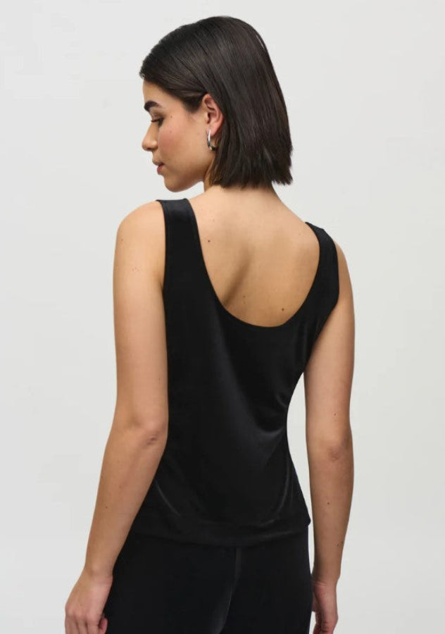 Woman wearing a black sleeveless top against a white background