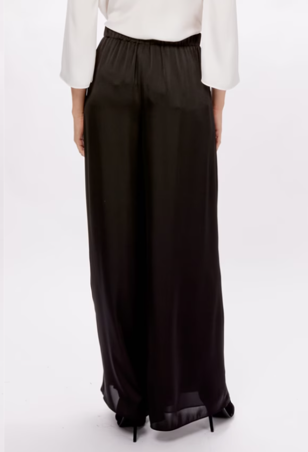 Black wide-leg pants worn with a white top on a white background
