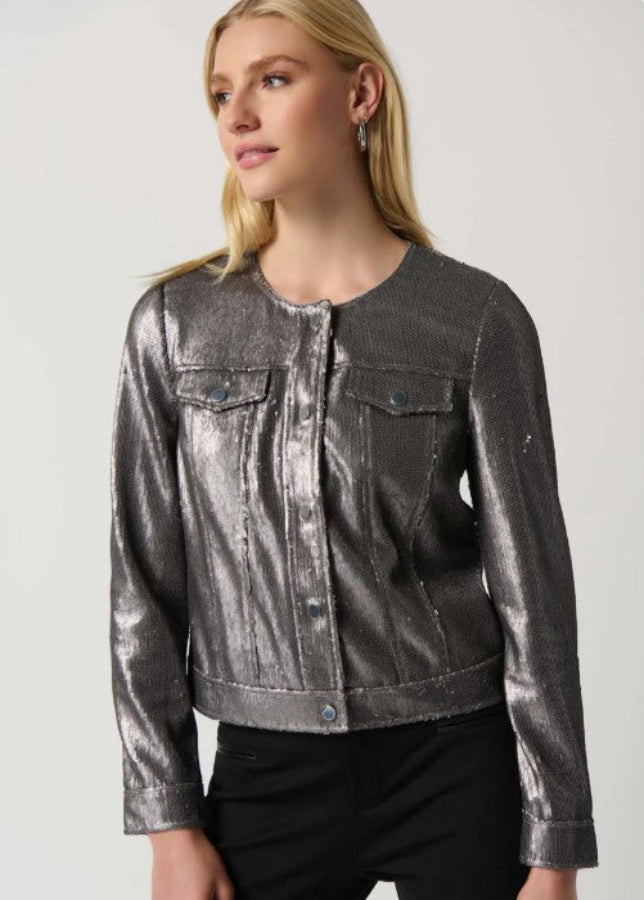 Woman wearing a metallic silver jacket on a plain background