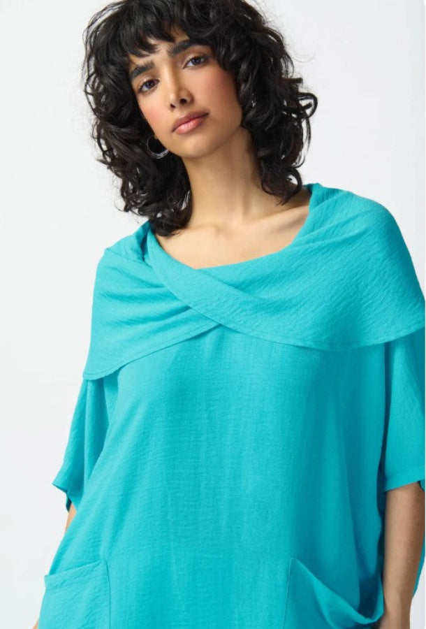 Woman wearing a turquoise top against a white background