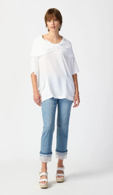 Woman wearing a white top and light blue jeans on a white background