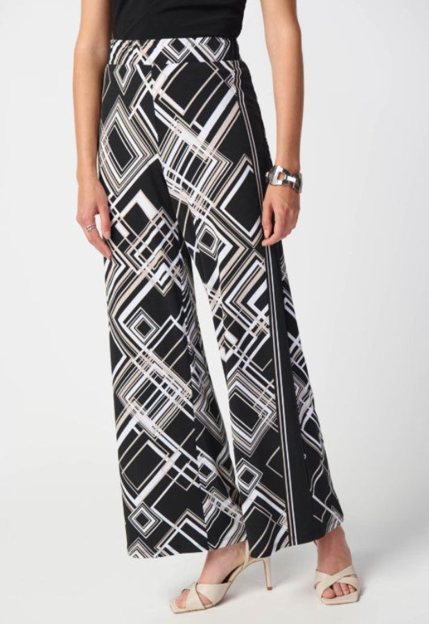 Person wearing a black and white geometric patterned skirt on a white background