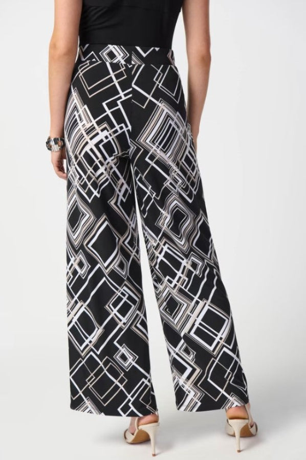 Person wearing a black and white geometric patterned skirt on a white background