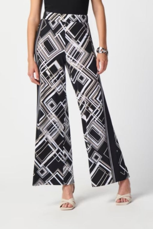 Black and white geometric patterned pants worn by a person on a white background