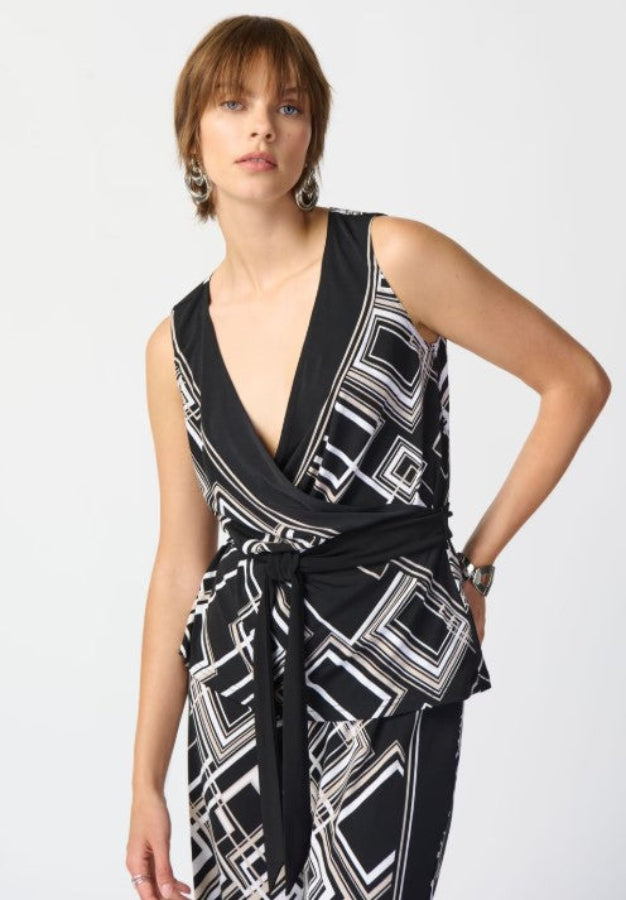 Woman wearing a black and white patterned top on a plain background
