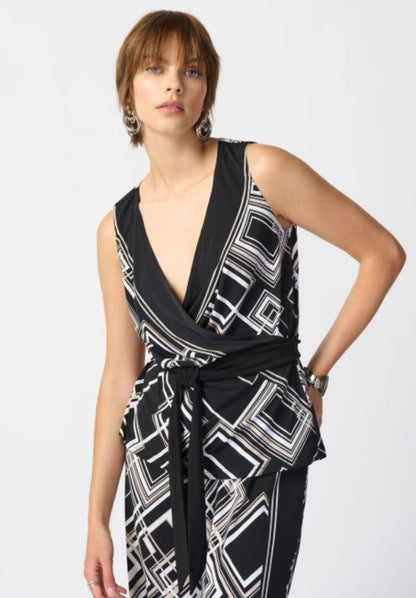 Woman wearing a black and white patterned top on a plain background