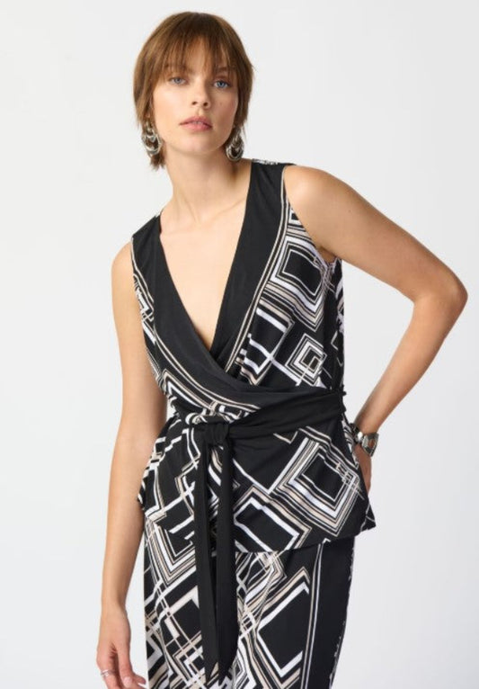 Woman wearing a black and white patterned top on a plain background