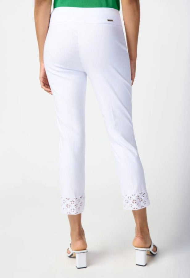 White pants with lace trim worn by a person on a white background