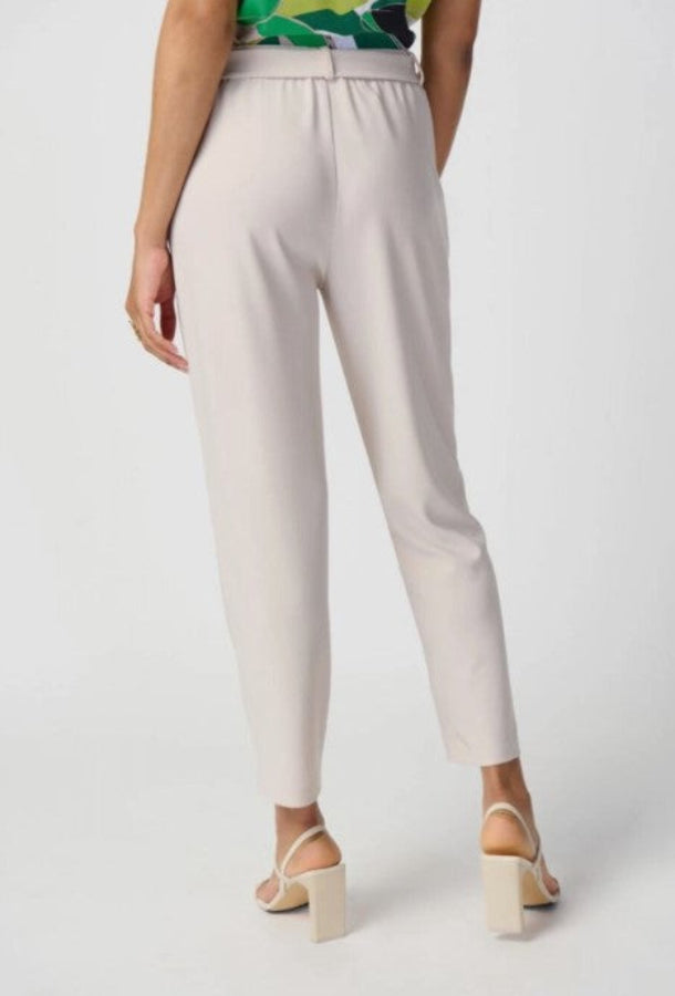 Beige pants worn by a person on a white background