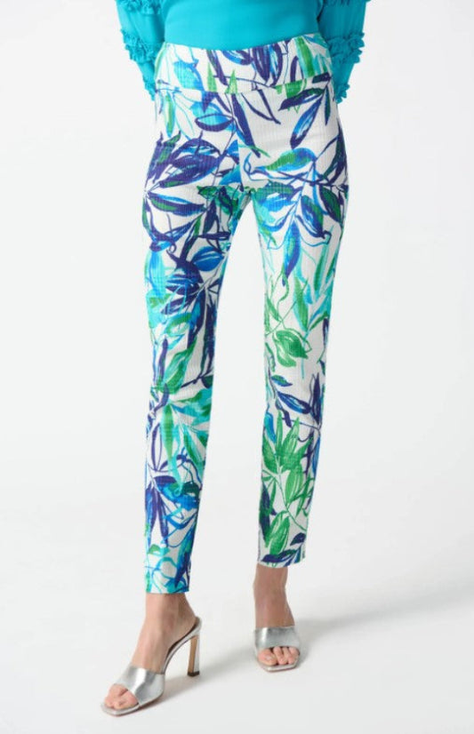 Tropical leaf patterned pants worn by a person on a white background