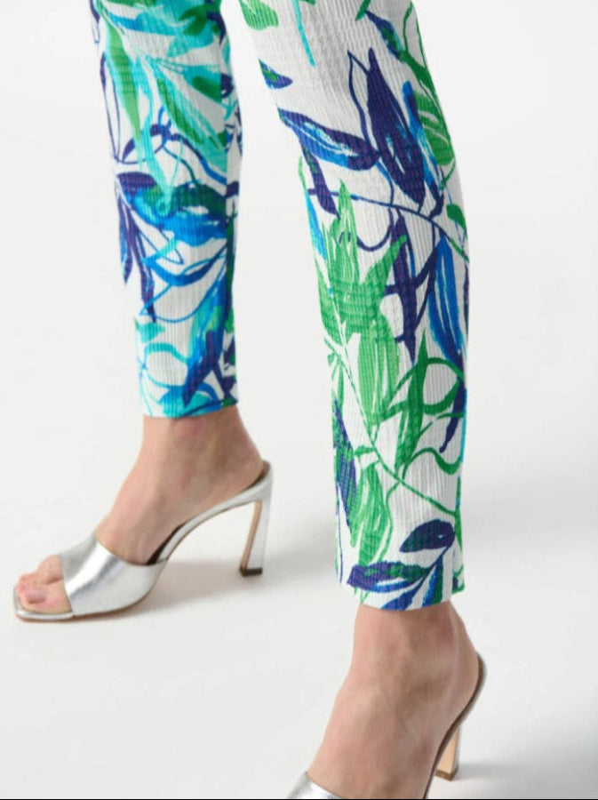 Colorful tropical print pants worn with silver high-heeled sandals on a white background