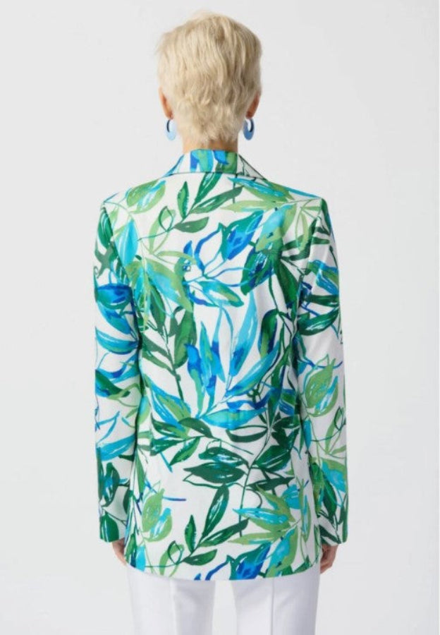 Person wearing a colorful leaf-patterned blazer on a white background