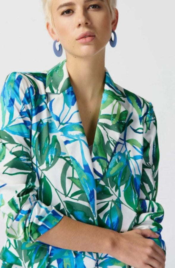 Person wearing a colorful leaf-patterned blazer on a white background