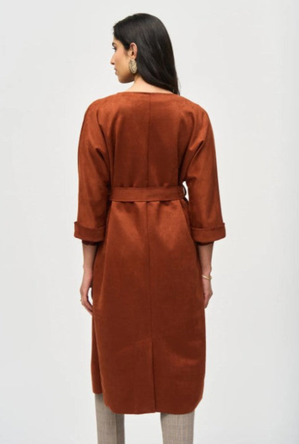 Woman wearing a brown suede coat against a white background