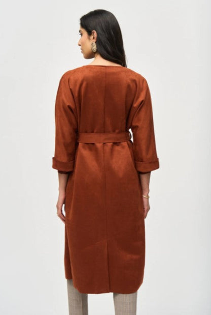 Woman wearing a brown suede coat against a white background