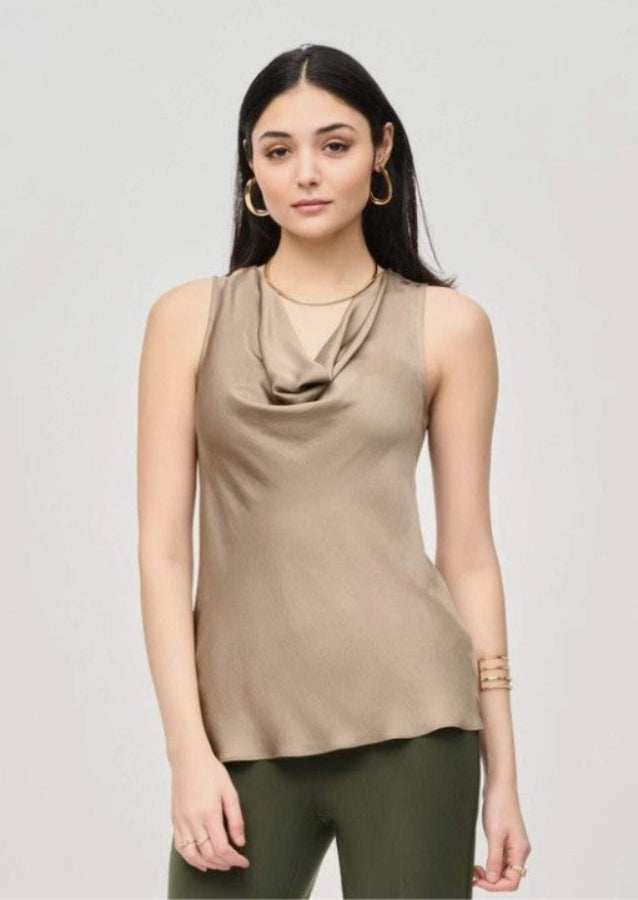 Woman wearing a beige sleeveless top with a draped neckline on a light gray background