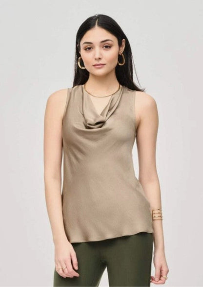 Woman wearing a beige sleeveless top with a draped neckline on a light gray background