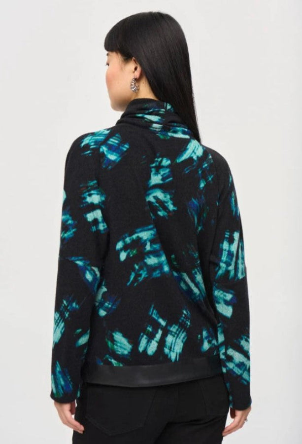 Person wearing a black and blue patterned sweater top on a white background