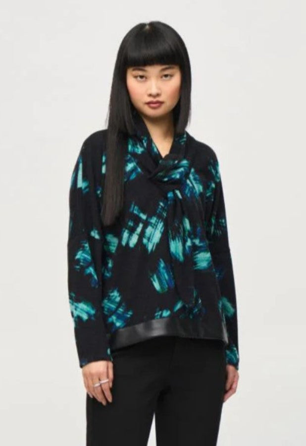 Woman wearing a black and blue patterned top against a white background