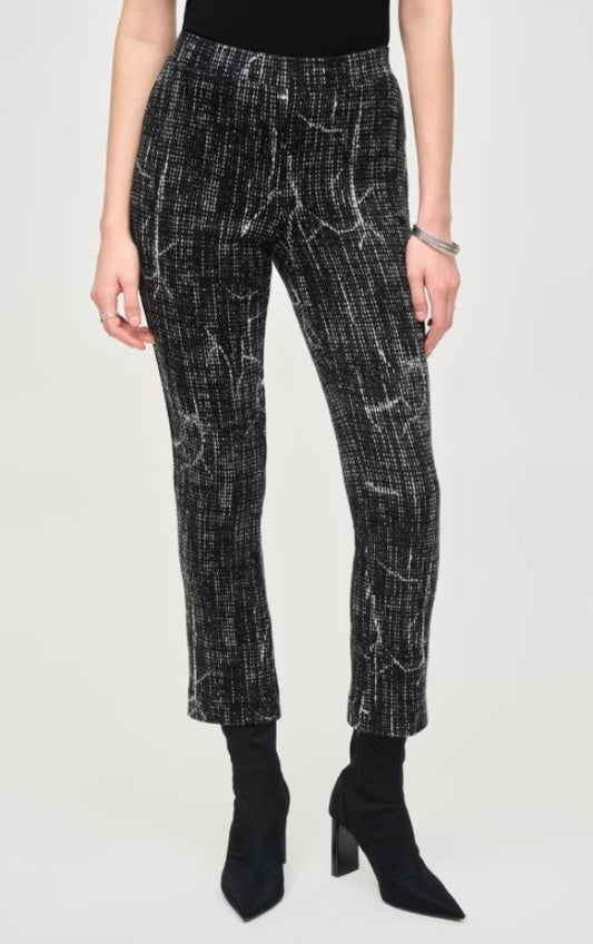 Person wearing black and white patterned pants on a white background