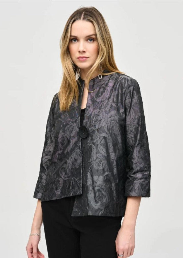 Woman wearing a patterned black jacket on a light gray background