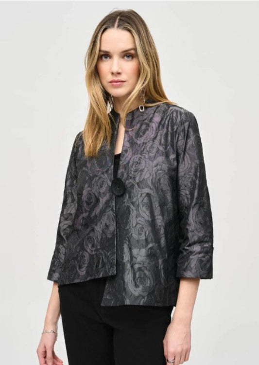 Woman wearing a patterned black jacket on a light gray background