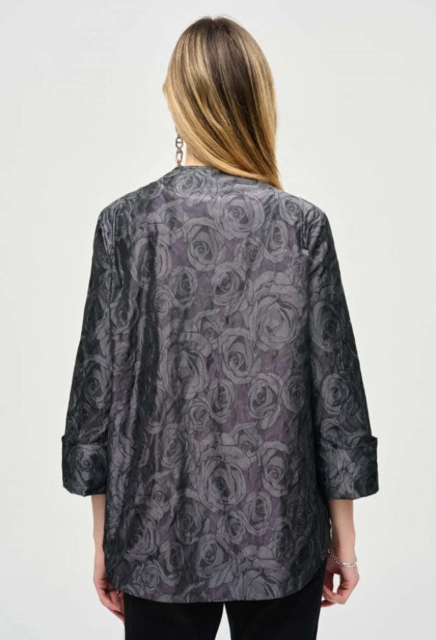 Person wearing a patterned gray jacket on a white background