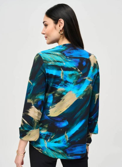 Woman wearing a colorful abstract patterned jacket on a plain background