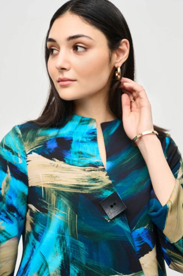 Woman wearing a colorful abstract patterned jacket with a plain background