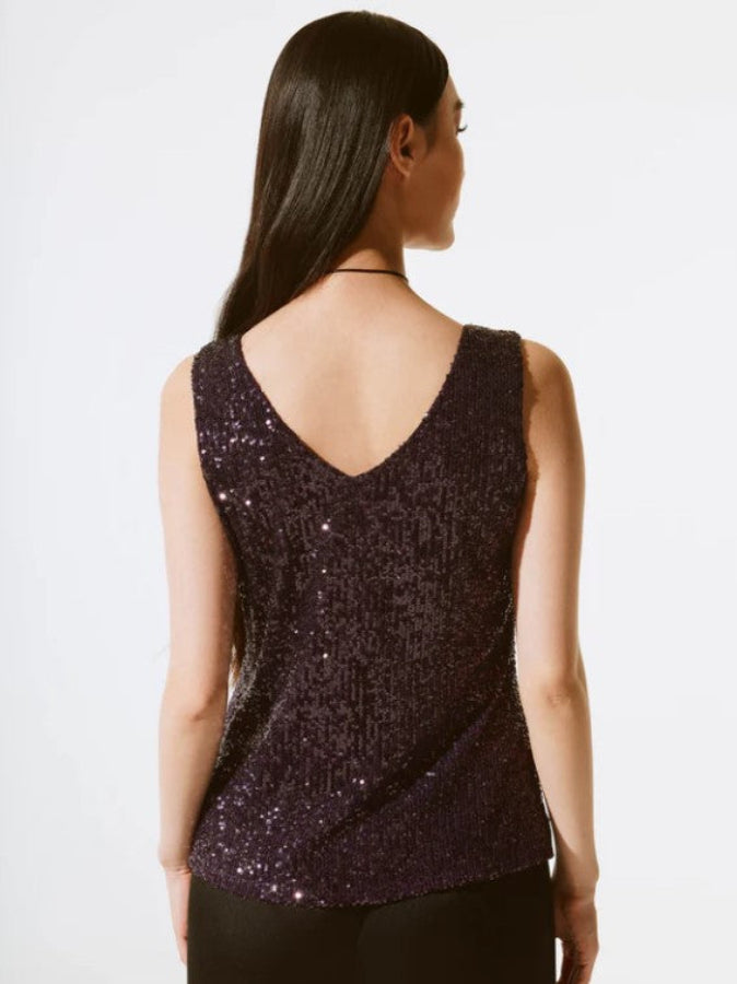 Woman wearing a sequined top on a white background