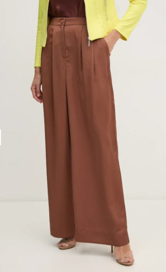 Brown wide-leg pants worn with a yellow top on a white background