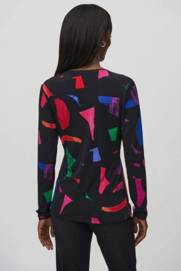 Person wearing a black long-sleeve top with colorful geometric pattern on a white background