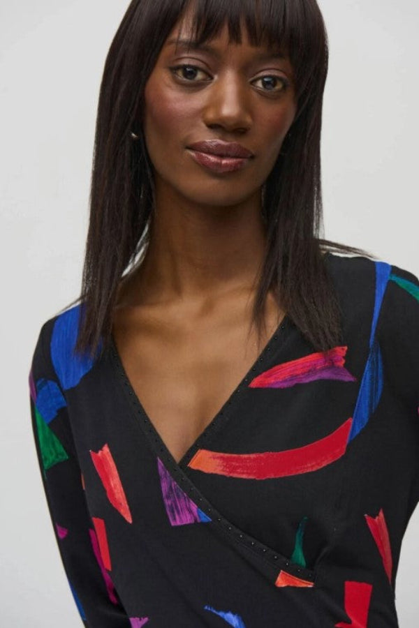 Woman wearing a black dress with colorful abstract patterns on a white background