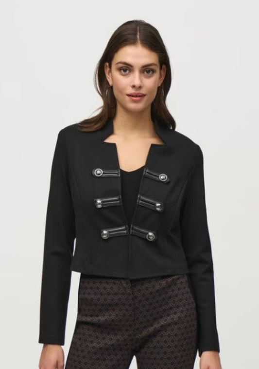 Woman wearing a black jacket with decorative buttons on a white background